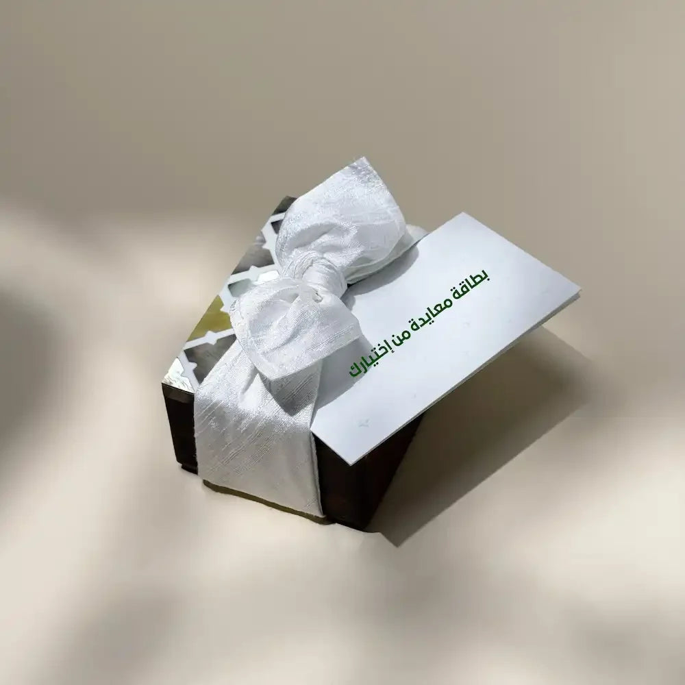 Mother of pearl cash box tied with off white fabric bow, greeting card on top