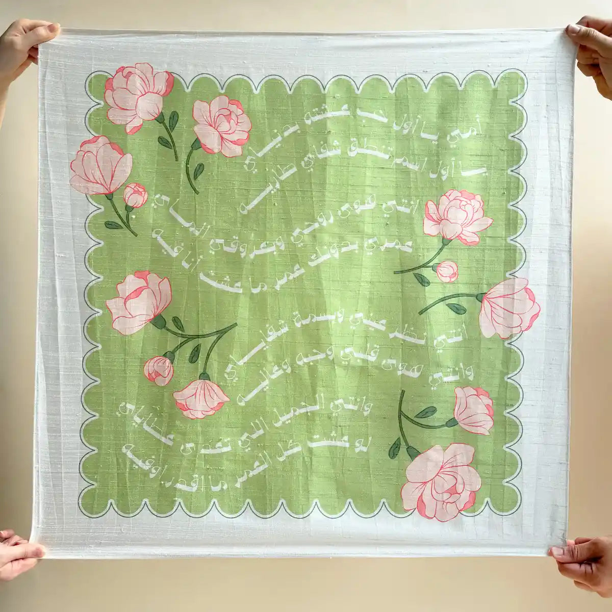 Green floral fabric gift wrap with Arabic poetry print, held open flat