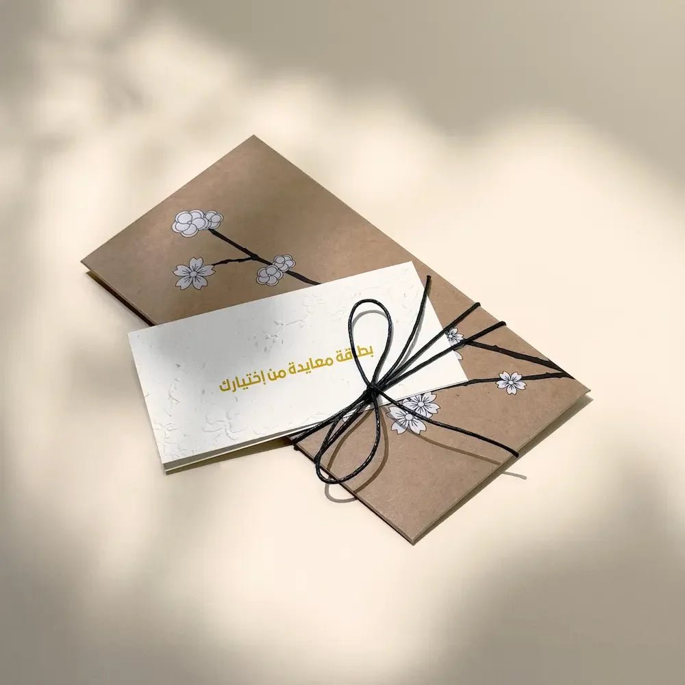 Kraft cash envelope with cherry blossom print, tied in black cord, greeting card tucked in