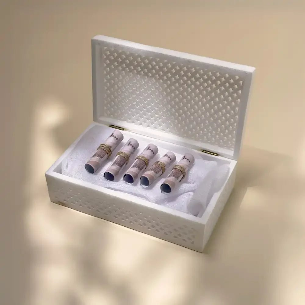 Open white marble box showing rolled cash bundles tied with twine inside