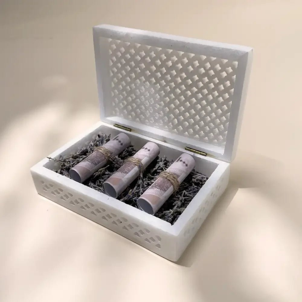 Open marble-style gift box showing cash rolls nestled in dried lavender