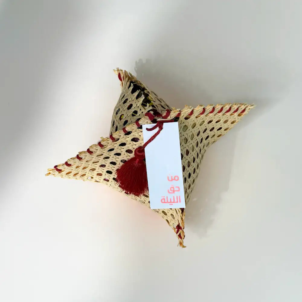 Star-shaped rattan pouch viewed from above, red tassel and gift tag