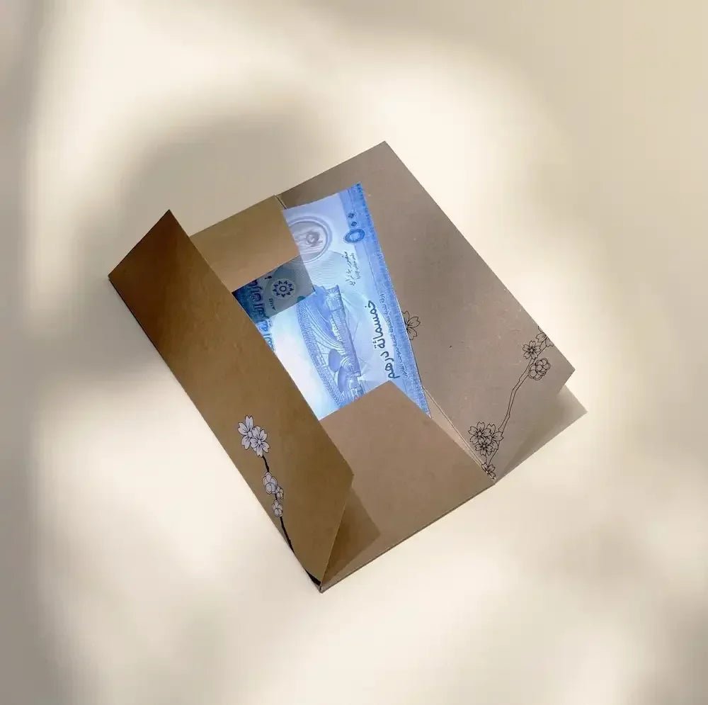 Cherry blossom cash envelope opened to show folded dirham notes inside