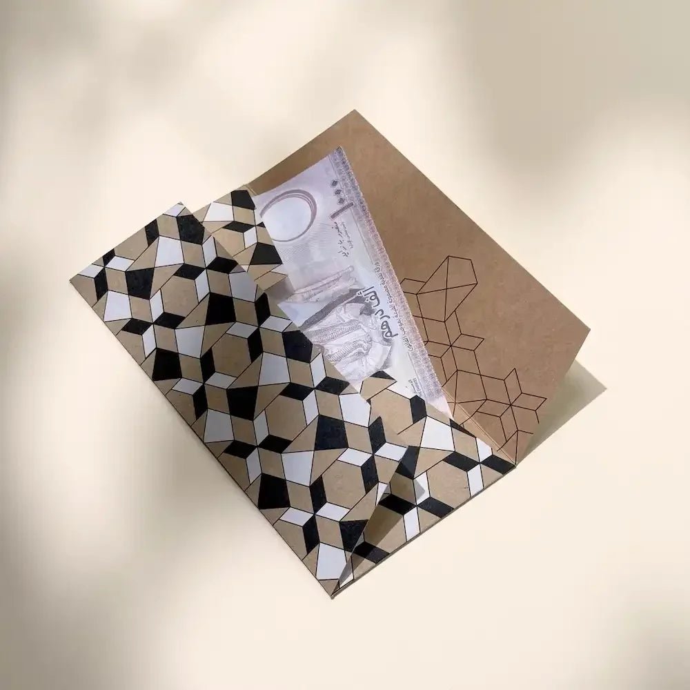 Folded geometric money envelope open to reveal cash tucked inside, close angle