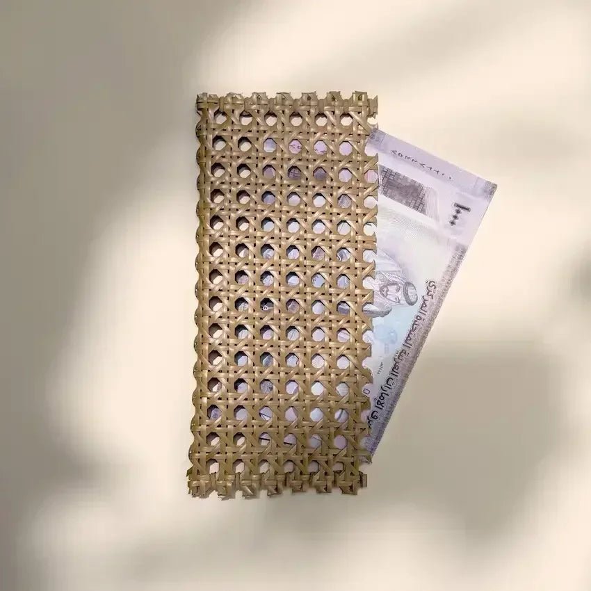 Woven rattan money pouch holding a UAE dirham note, top view on beige backdrop