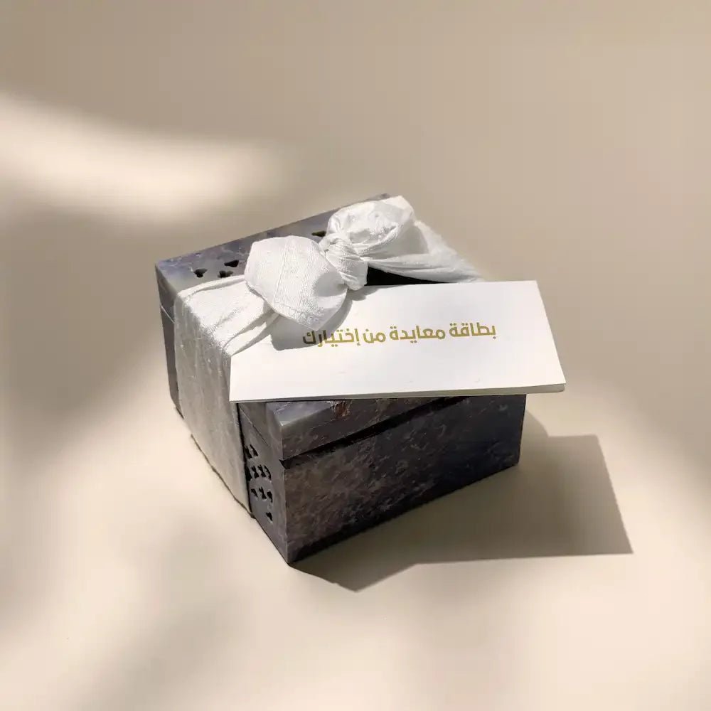 Carved soapstone cash box tied with off white fabric bow and greeting card