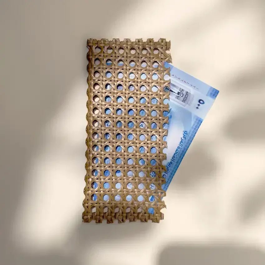 Rattan cash wallet with a blue banknote tucked inside, soft natural light