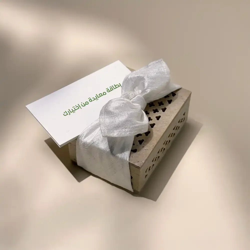 Carved stone cash box tied with off white fabric bow and greeting card