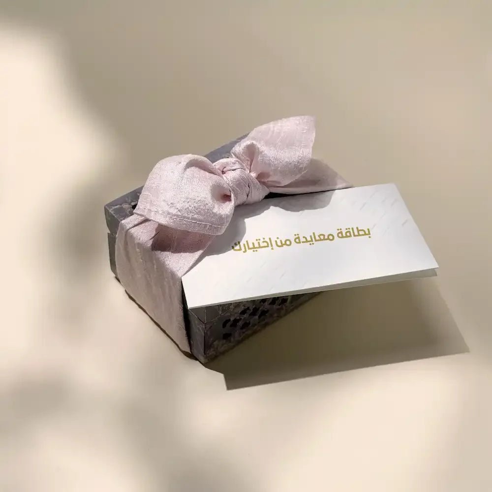 Carved stone cash box tied with pastel pink bow and blank greeting card