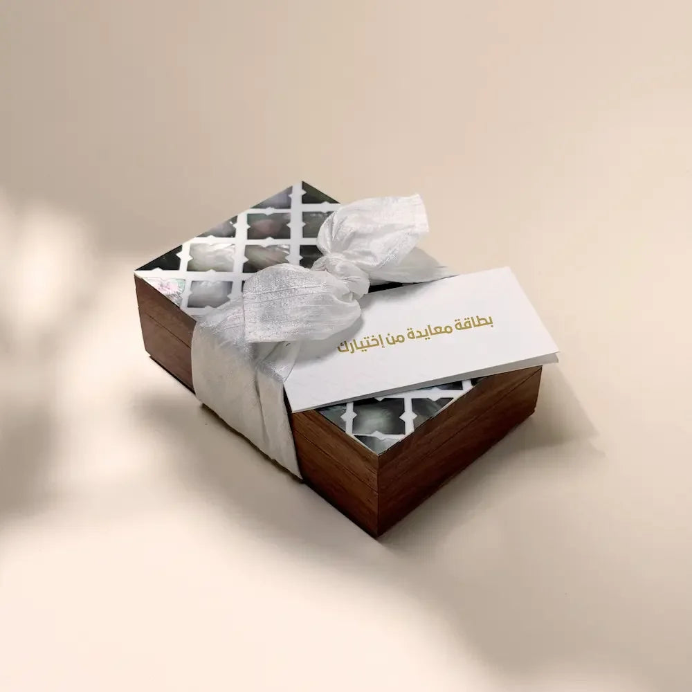Rosewood cash box with cutout lid, wrapped in off-white fabric bow and greeting card