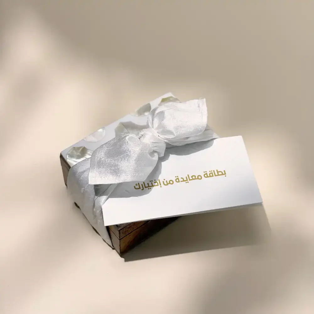 Rosewood mini box wrapped in off white fabric bow with greeting card