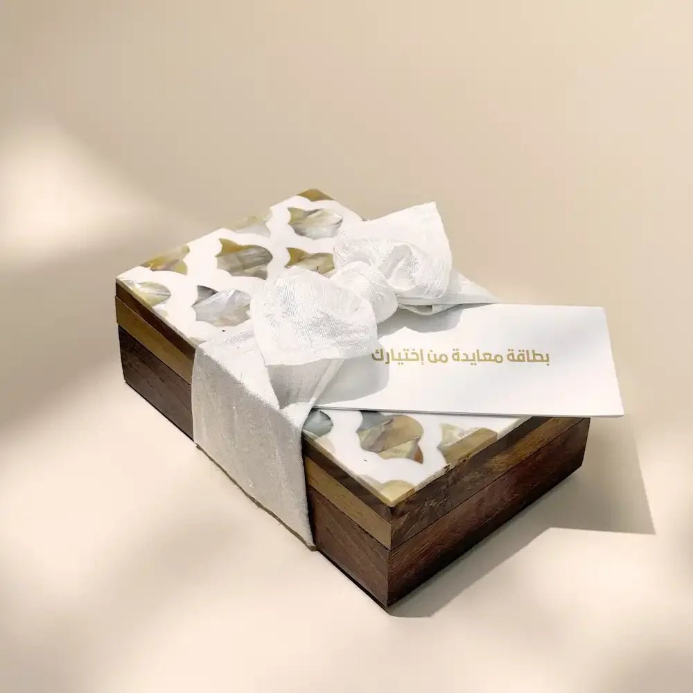Rosewood cash box wrapped in off white fabric bow with greeting card tucked in