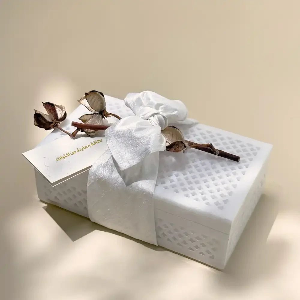 White marble-style cash box wrapped with fabric bow and dried cotton flowers