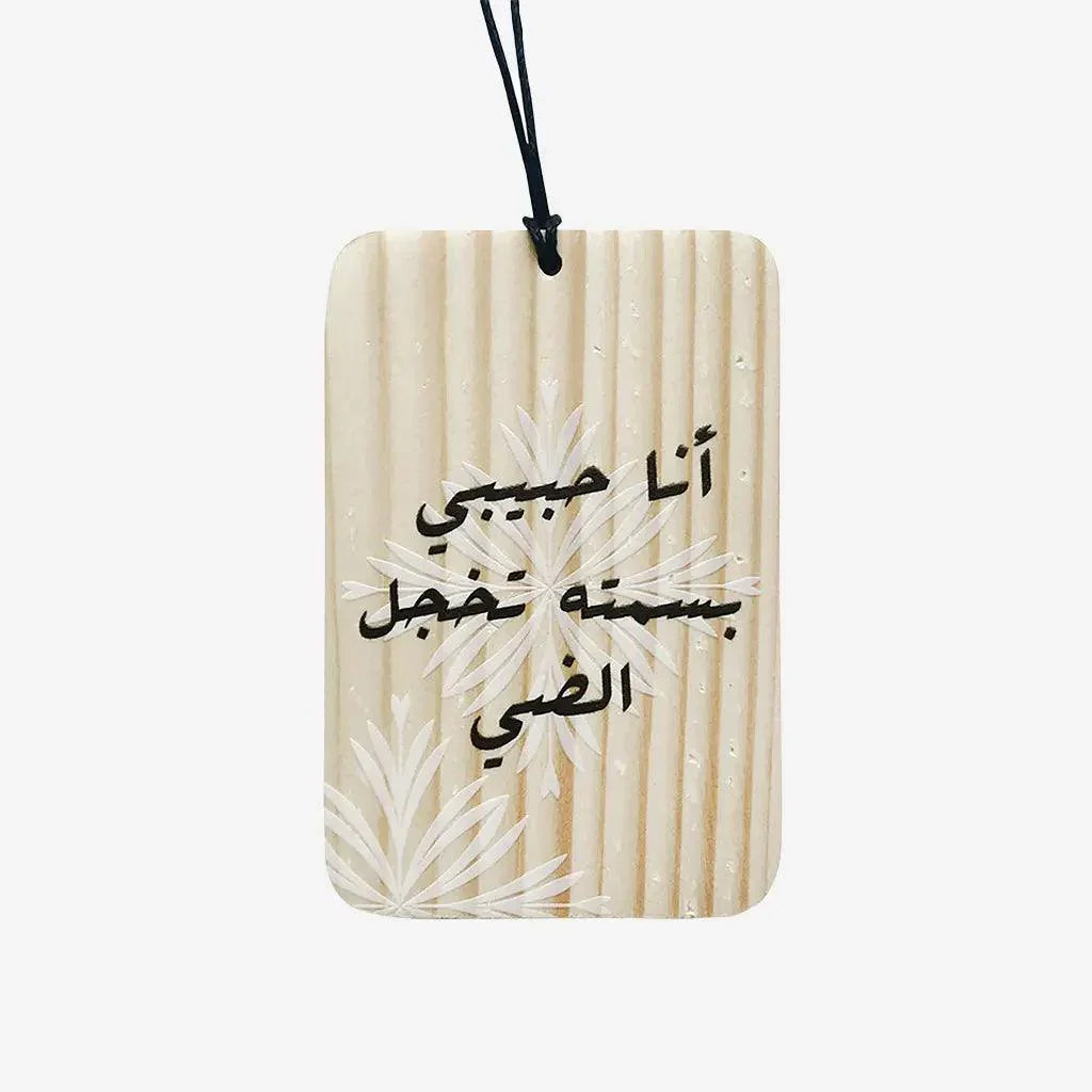Wooden hanging trinket with carved floral design and Arabic script charm