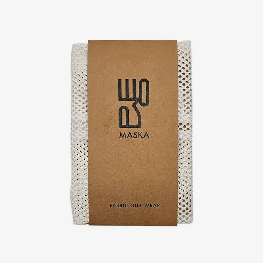 White mesh fabric gift wrap folded with kraft paper band, front view