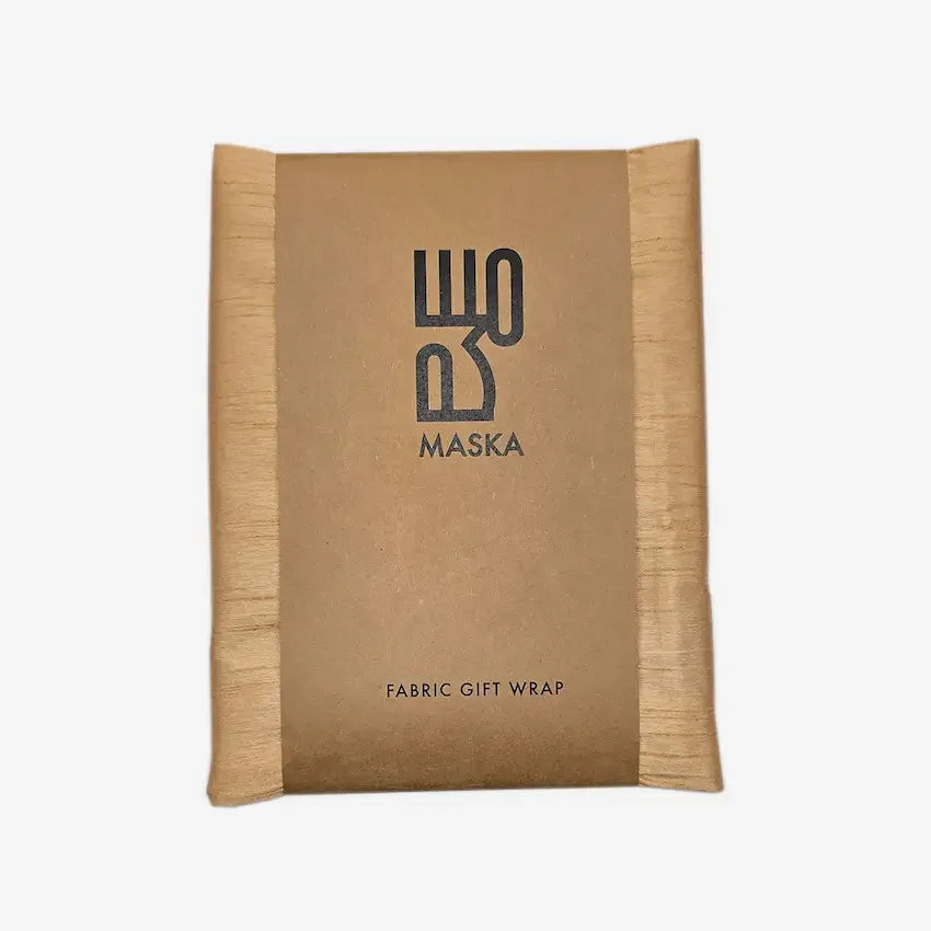 Nude raw silk gift wrap folded in kraft paper sleeve with Maska branding