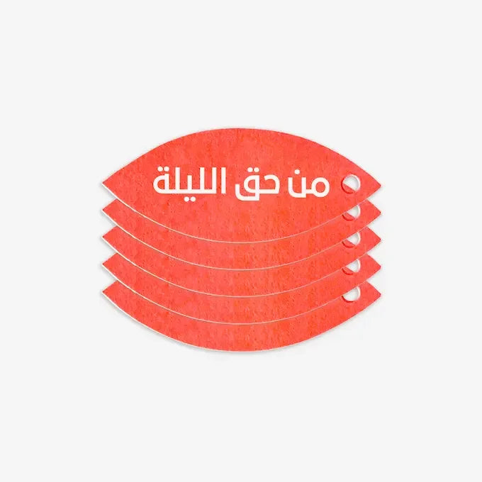 Stacked orange eye-shaped gift tags printed with 'Hag Al Laila' in white Arabic script