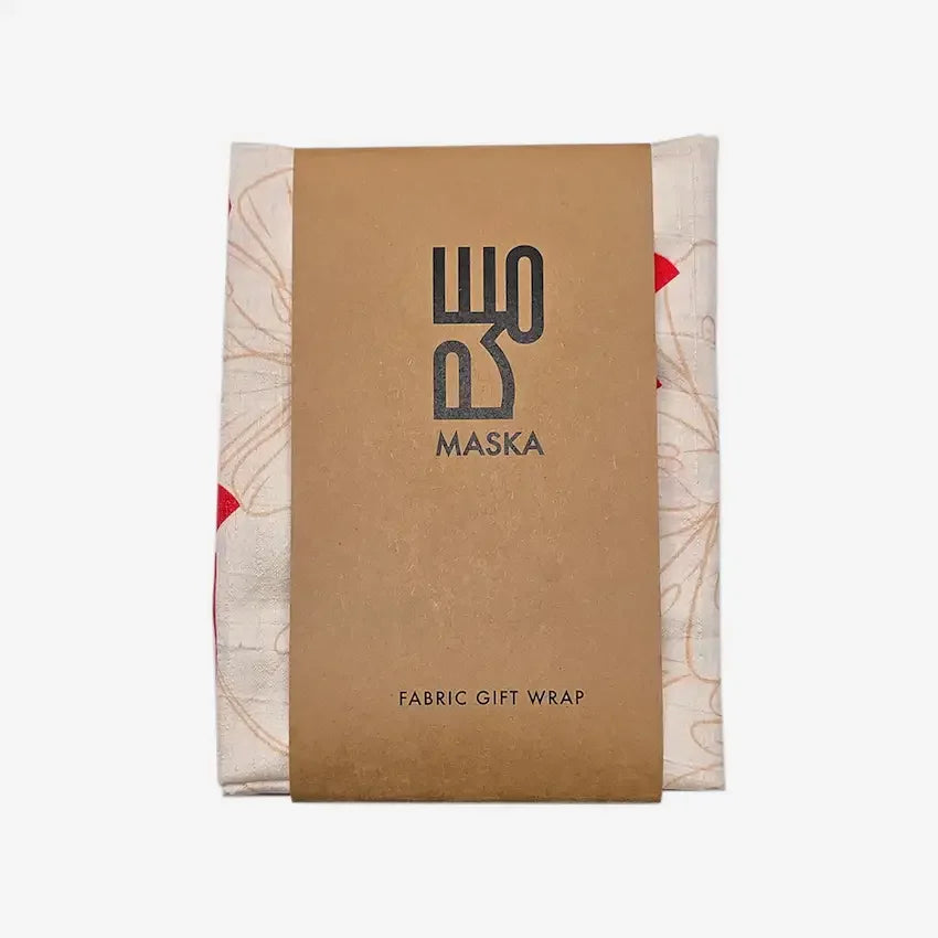 Printed raw silk gift wrap in cream and red, folded with Maska kraft wrap band