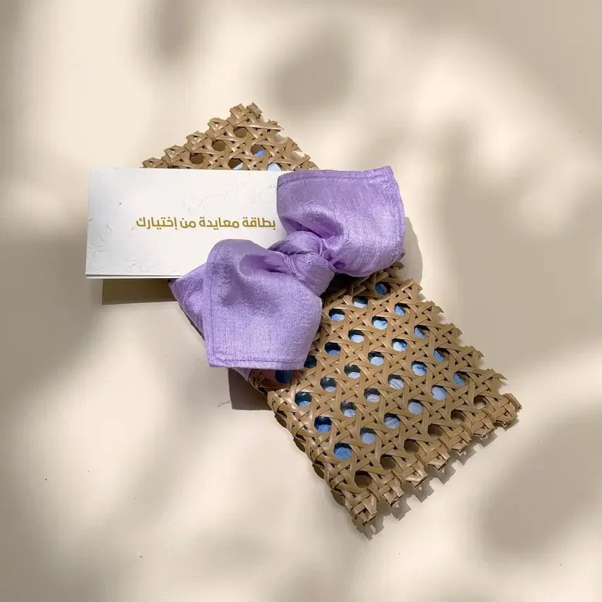Rattan cash pouch with lavender fabric bow and matching greeting card, top view