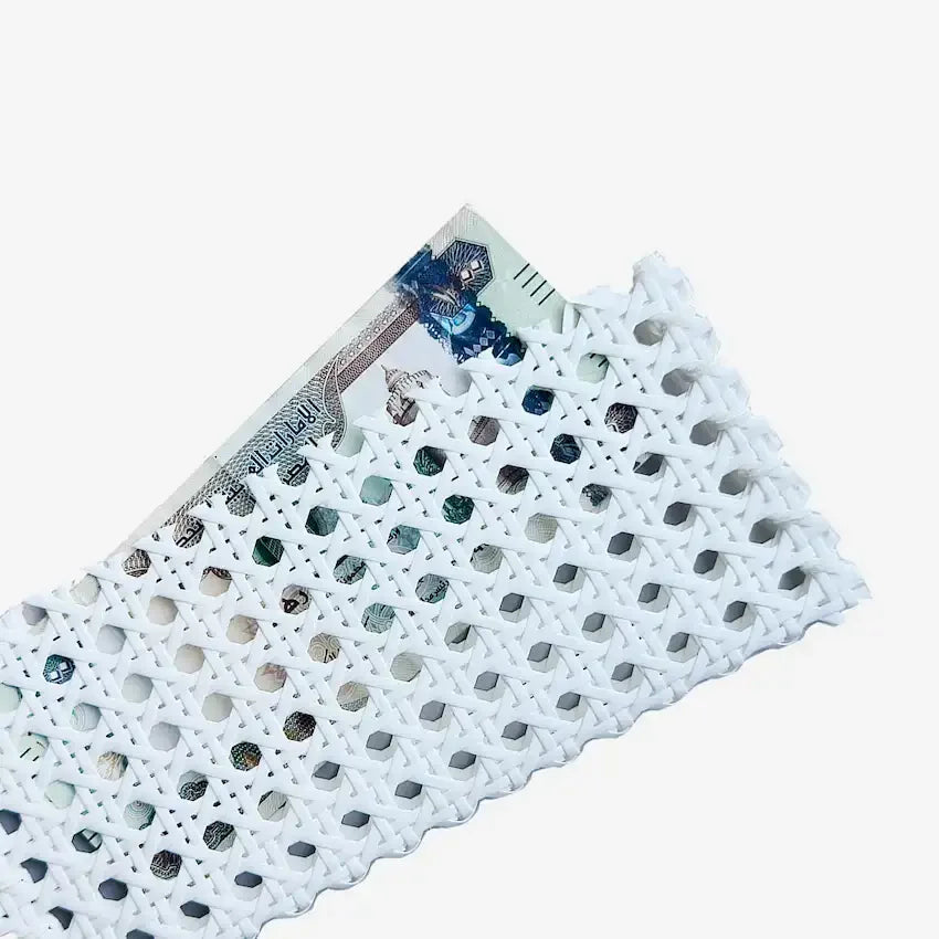 White rattan weave money pouch holding a folded UAE dirham note, close angle
