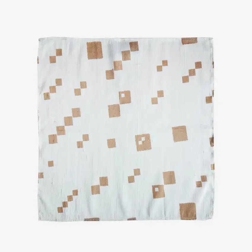 White fabric gift wrap with gold diagonal dot pattern, flat lay view