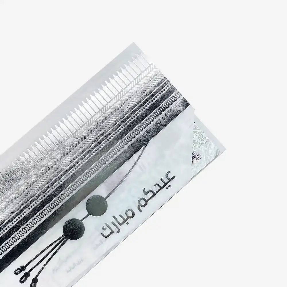 Close-up diagonal angle of Eid envelope showing bisht trim and Eid Mubarak script