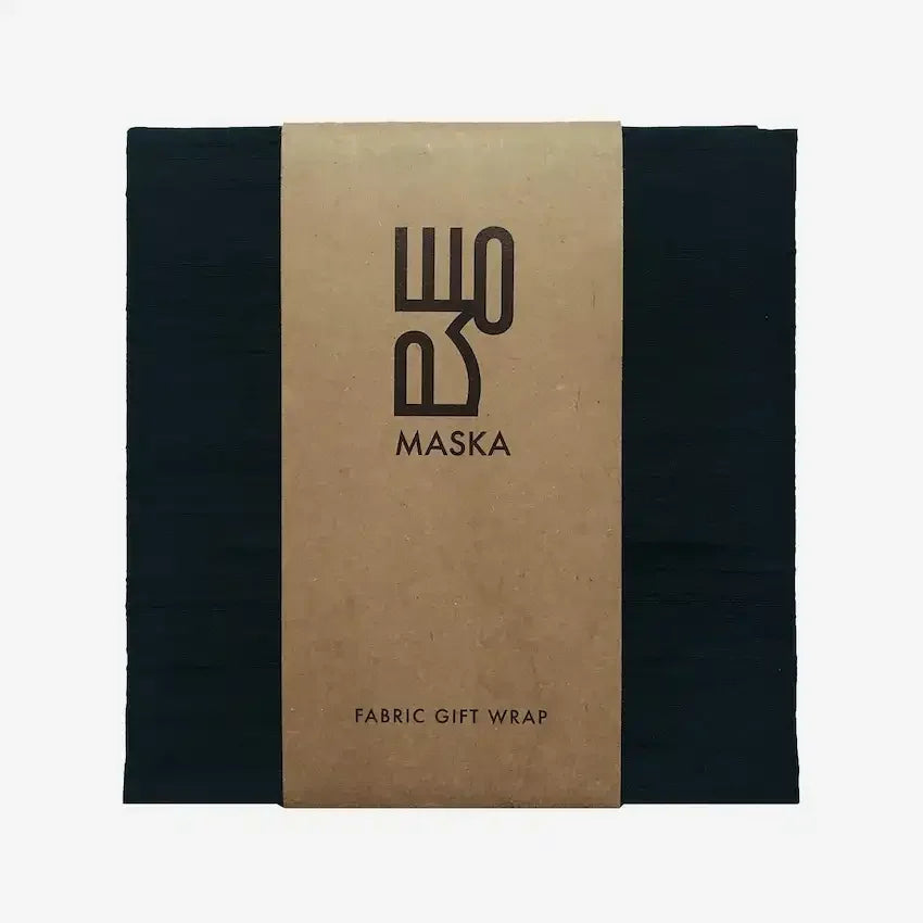 Black raw silk gift wrap folded with kraft paper band labelled Maska fabric gift wrap