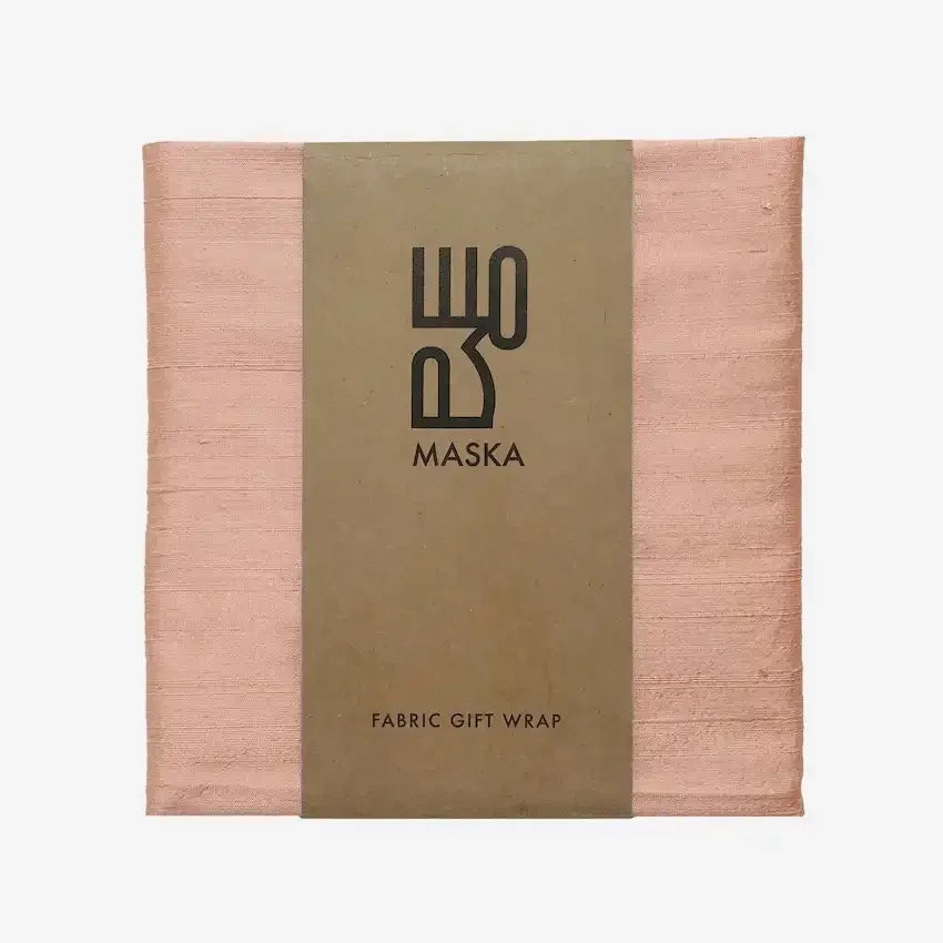 Peach raw silk gift wrap folded neatly with Maska branded fabric wrap band