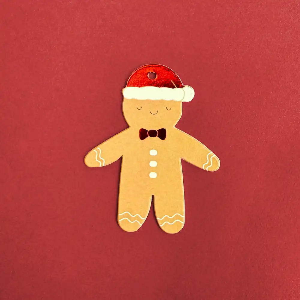 Gingerbread man Christmas trinket with Santa hat and bow tie on red backdrop