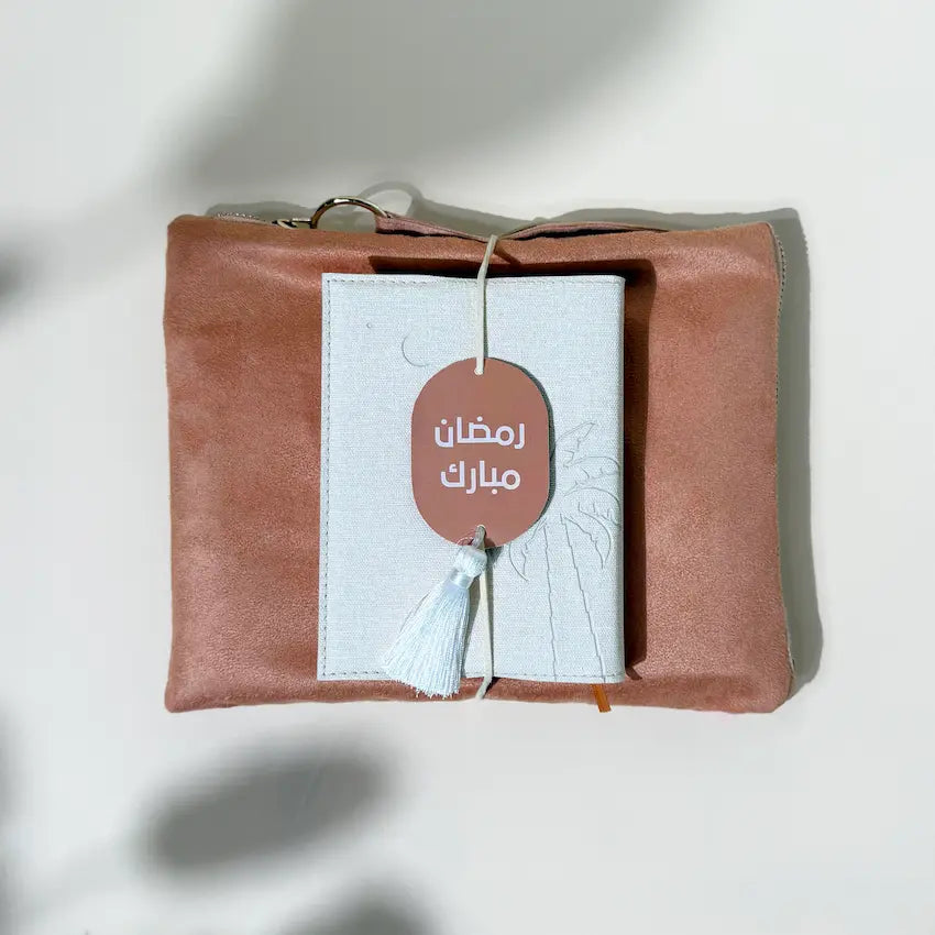 Ramadan Mubarak gift tag tied to prayer pouch and Quran, top view