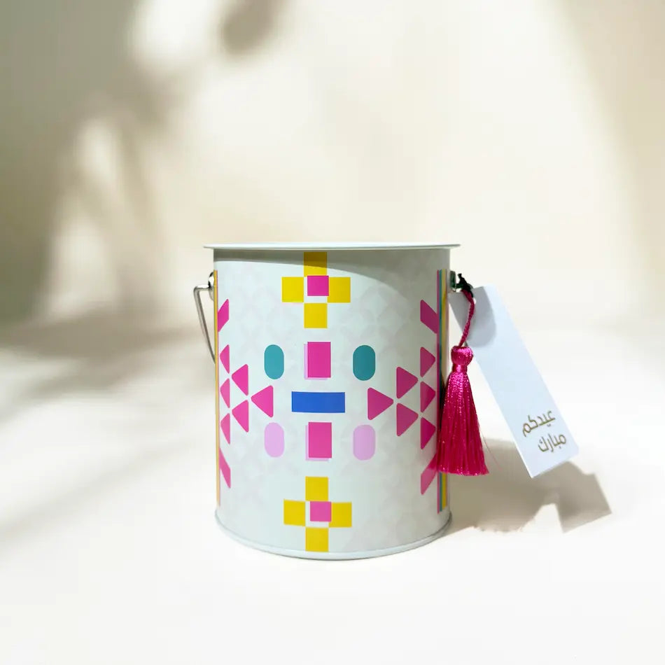 Beige Sadu-print metal can with handle and pink tassel gift tag