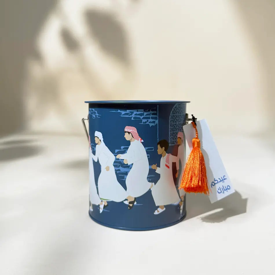 Navy metal can with Haq Al Laila children print, orange tassel and Eid greeting tag