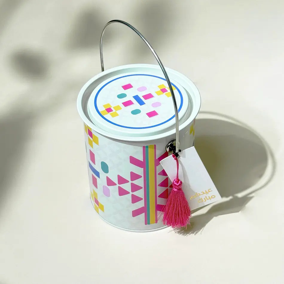 Top-down angle of beige patterned tin can showing lid design and tassel