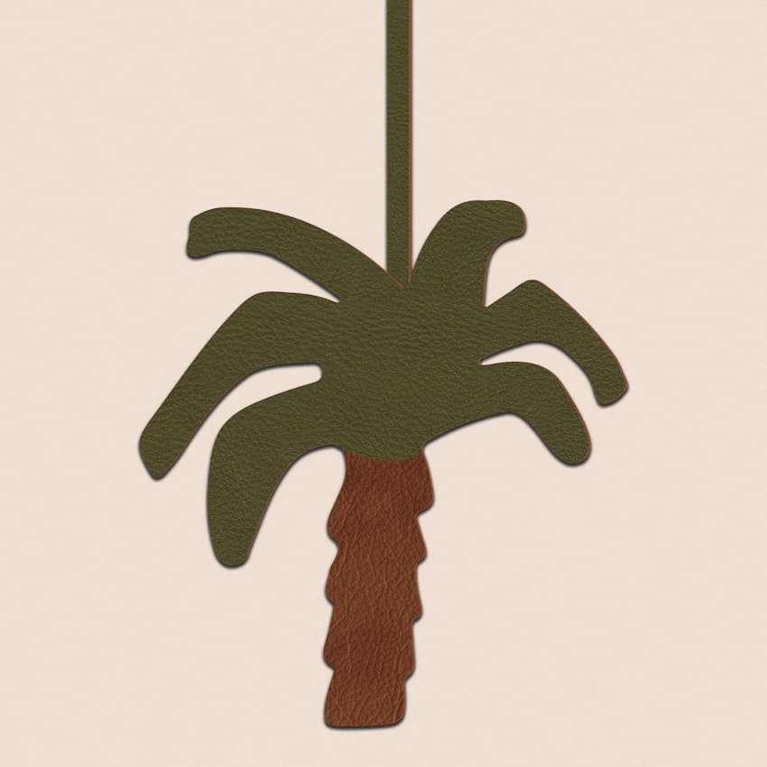Close-up of olive green and brown leather palm tree keychain charm