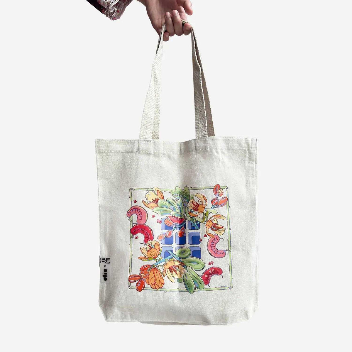 Canvas tote bag with floral mosaic print held by hand, Maska x Mariam Abbas