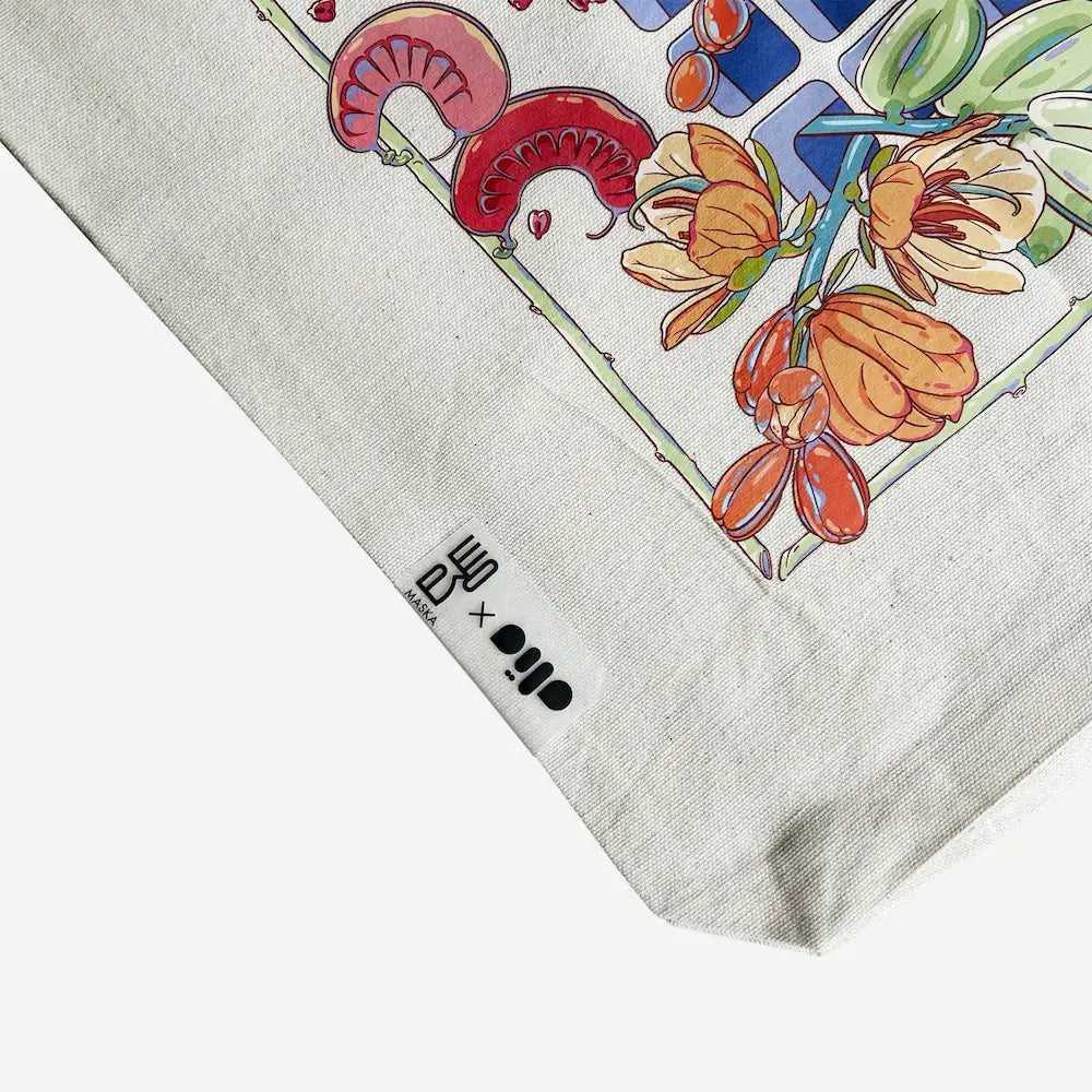 Close-up corner of canvas tote showing floral artwork detail and brand label