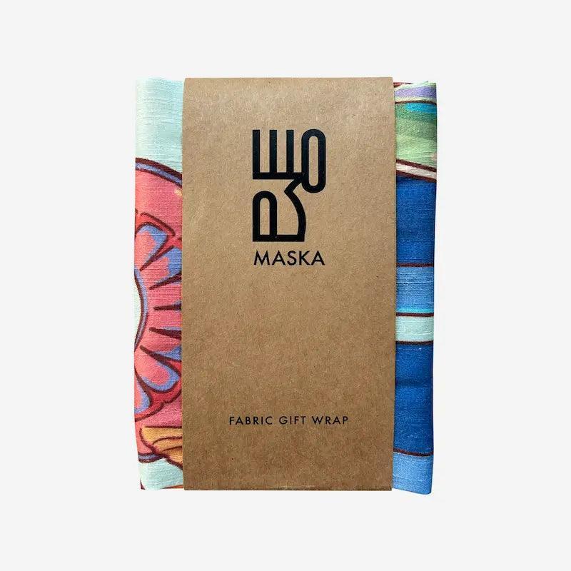 Folded floral fabric wrap in kraft paper sleeve branded Maska fabric gift wrap