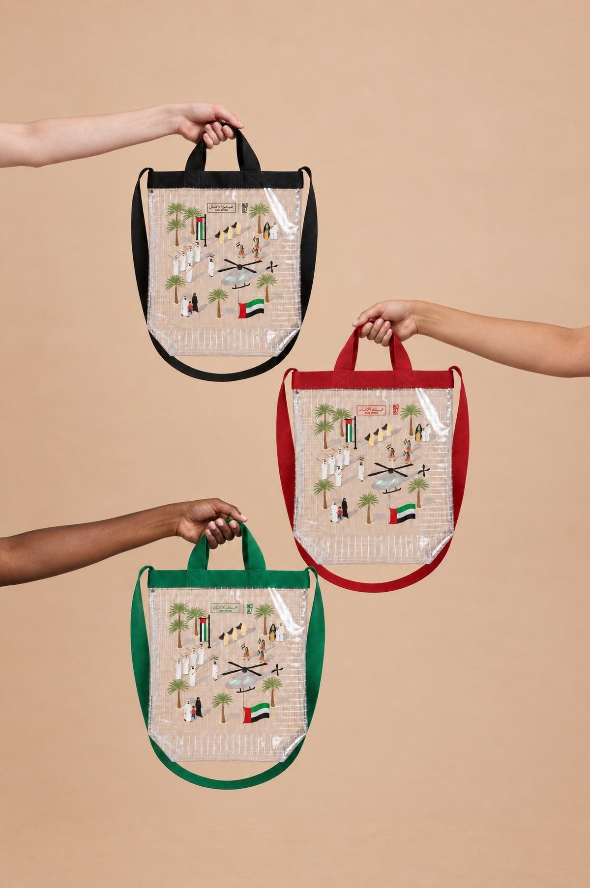 Three Eid Al Etihad clear tote bags in black, red and green held up together