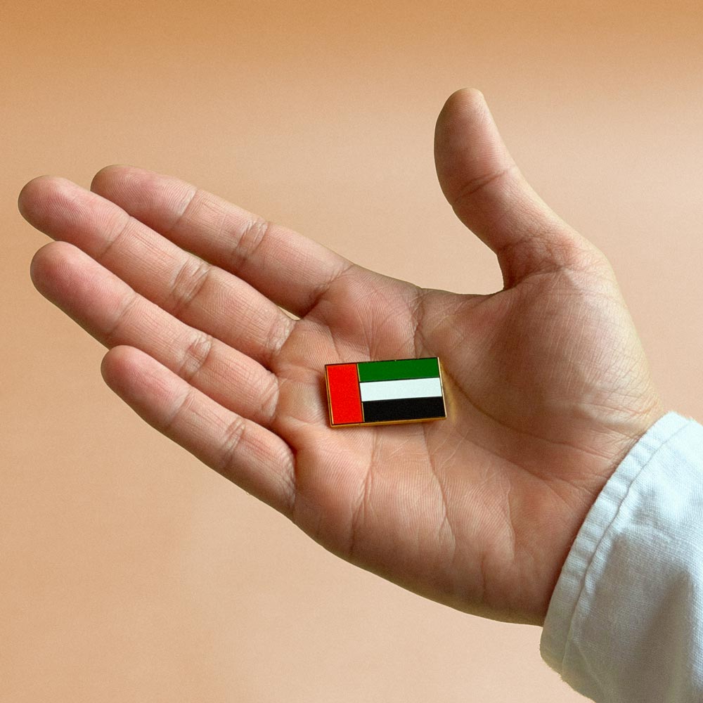 Eid Al Etihad 55 UAE flag pin held in the palm of a hand